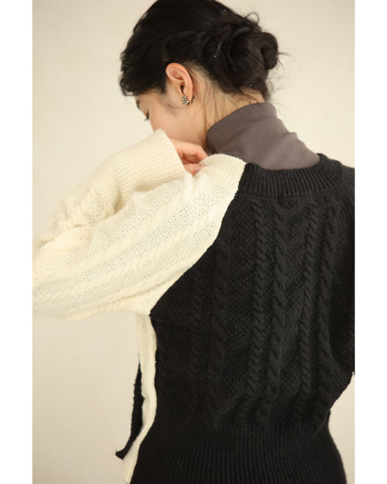 A knit pullover top with a black and white cache-coeur design