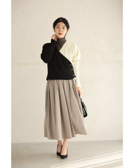 A knit pullover top with a black and white cache-coeur design