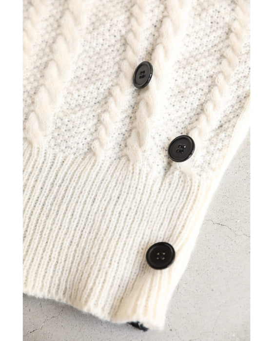 A knit pullover top with a black and white cache-coeur design
