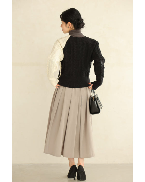 A knit pullover top with a black and white cache-coeur design