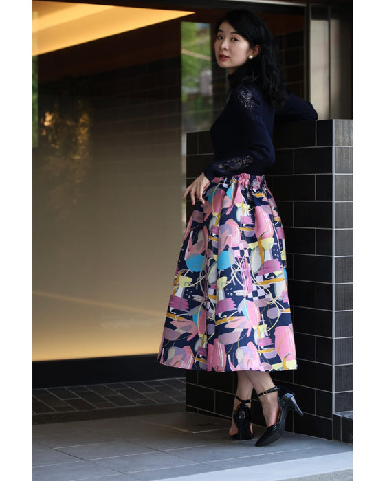 アーティスティックな世界観広がるタックミディアムスカート
