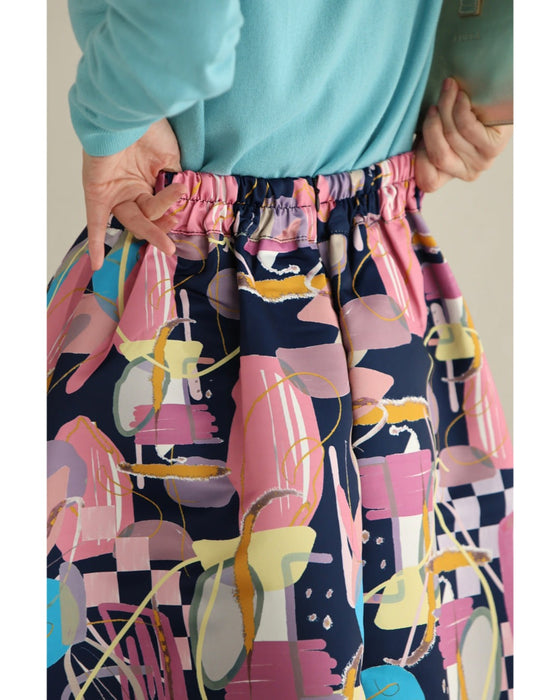 アーティスティックな世界観広がるタックミディアムスカート