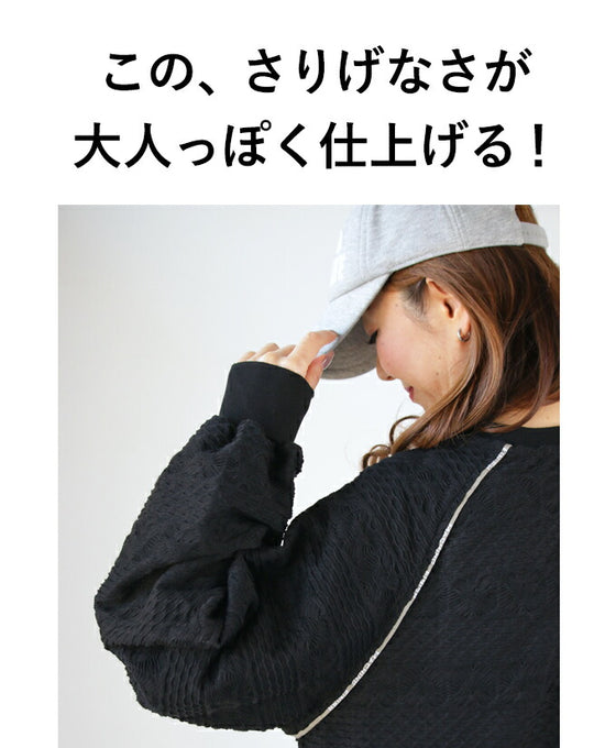 A knit top with a subtle piping logo and a raised fabric