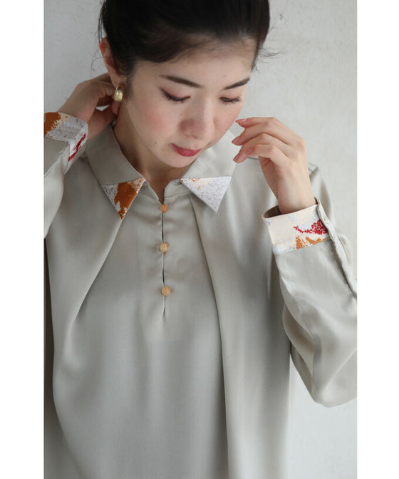 首から流れるタックのポイントアートブラウストップス