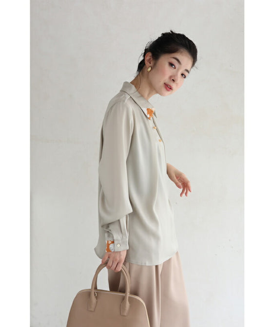 首から流れるタックのポイントアートブラウストップス