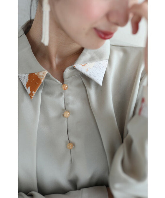 首から流れるタックのポイントアートブラウストップス