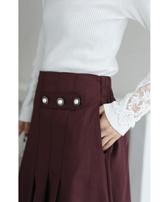 パールボタン連なるアシンメトリープリーツミディアムスカート